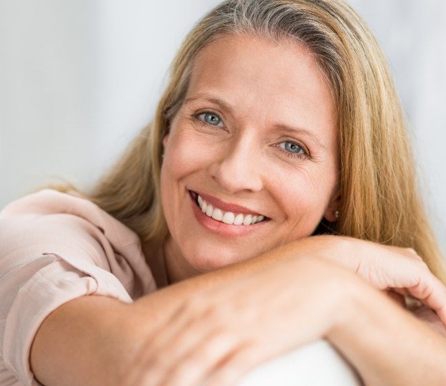 Woman smiling after metal free dental crown cosmetic dentistry treatment