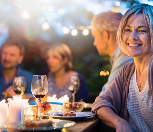 Woman smiling at dinner party with dental bridge in Dallas