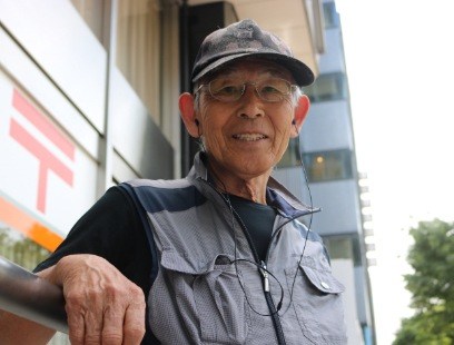 Older man wearing earbuds outdoors