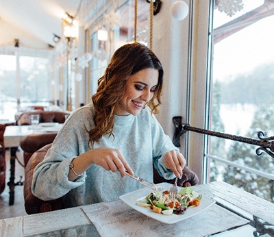 Woman smiling while eating healthy lunch at restaurant