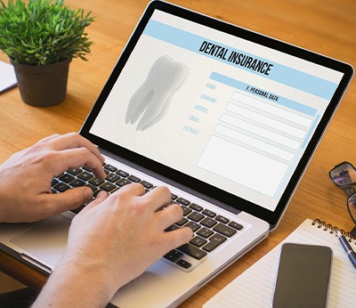 Patient filling out dental insurance form on computer