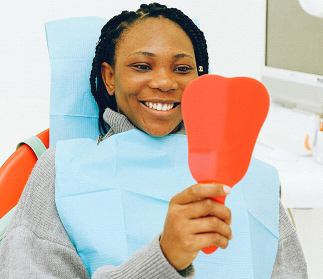 Woman at dentist appointment looking in mirror