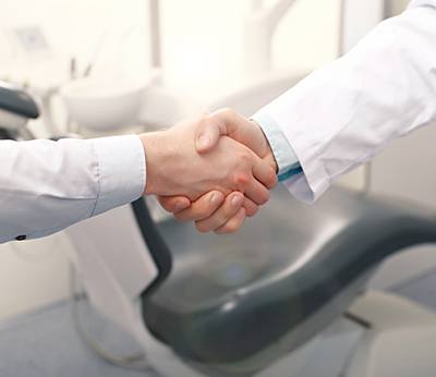 Patient shaking hands with a cosmetic dentist in Dallas, TX