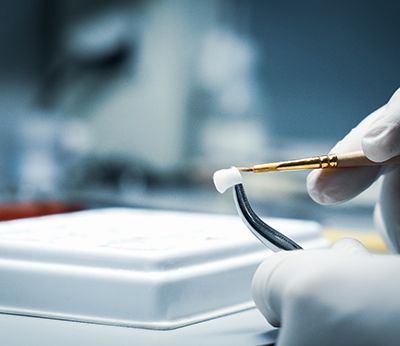 A lab worker processing a dental crown