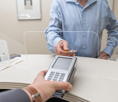 A man paying the cost of dental crowns