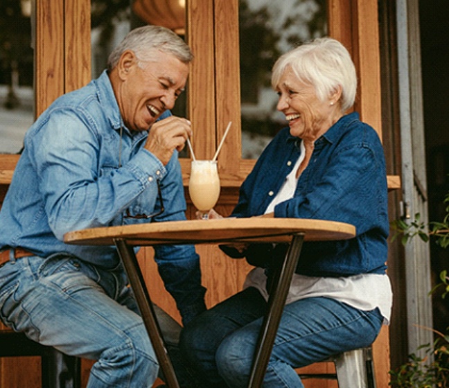 Older couple sharing a milkshake with dentures in Dallas