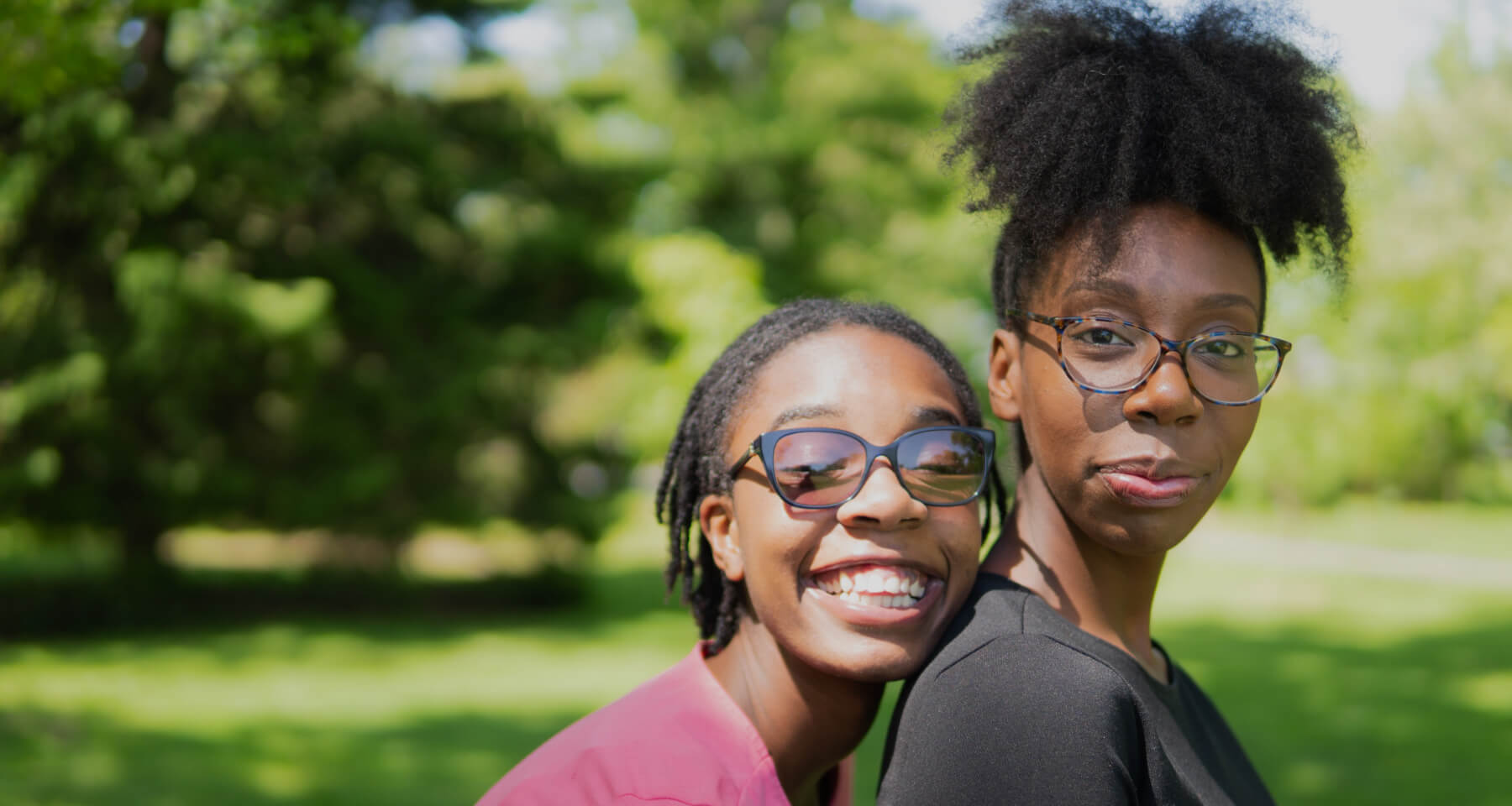 Two people smiling on a sunny day outdoors