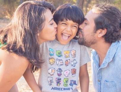 Mother and father kissing their child on the cheek