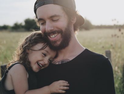Father and child laughing together after emergency dentistry