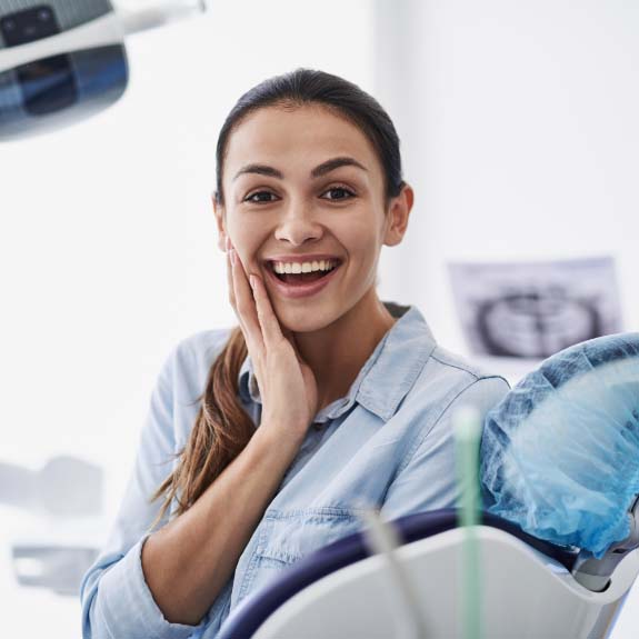 woman touching her face and smiling