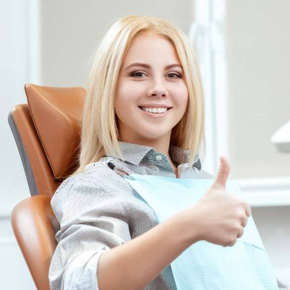 woman smiling with thumbs up