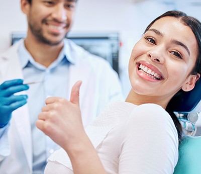 Smiling patient in treatment chair giving thumbs up