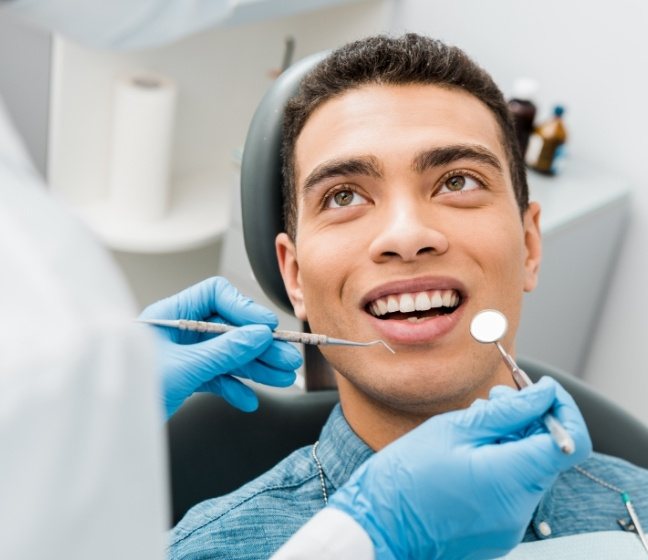 Man receiving preventive dentistry checkup and teeth cleaning