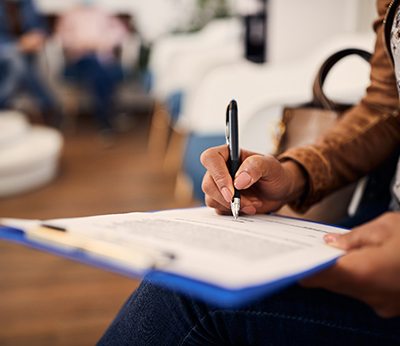 Patient in lobby filling out dental insurance form