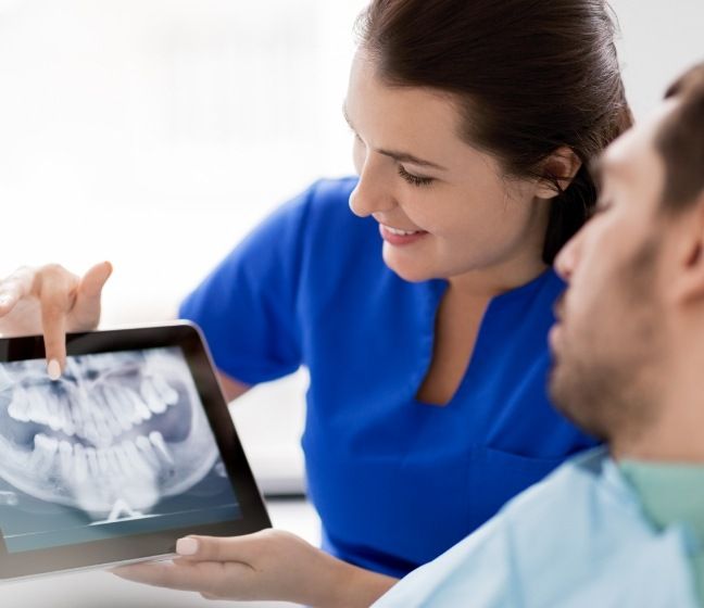 Dentist and patient looking at digital x-rays