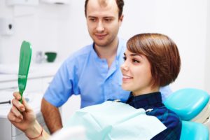 Woman in dentist’s chair looking in mirror