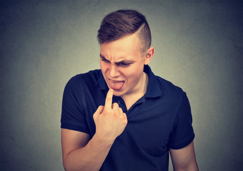 Man is displeased with scent coming from his mouth