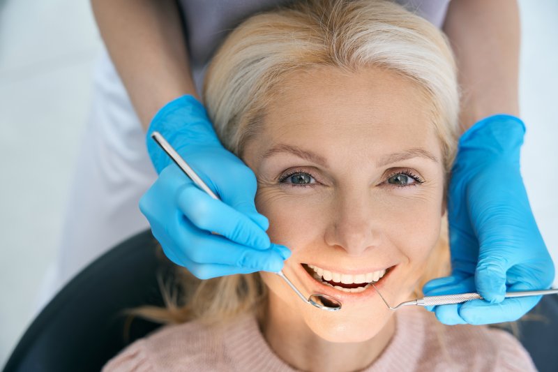 A smiling woman waiting for a dental crown treatment