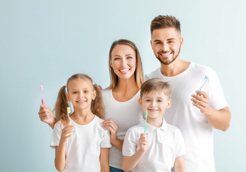 Family holding toothbrushes